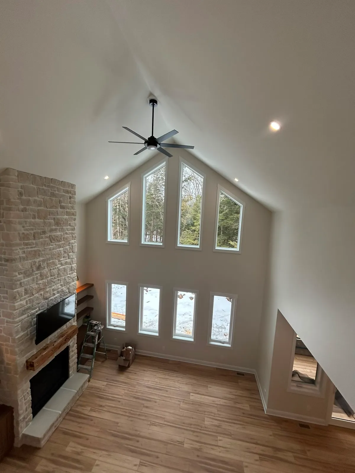 Freshly painted cathedral-ceiling living room with stone fireplace in a Lanark County home