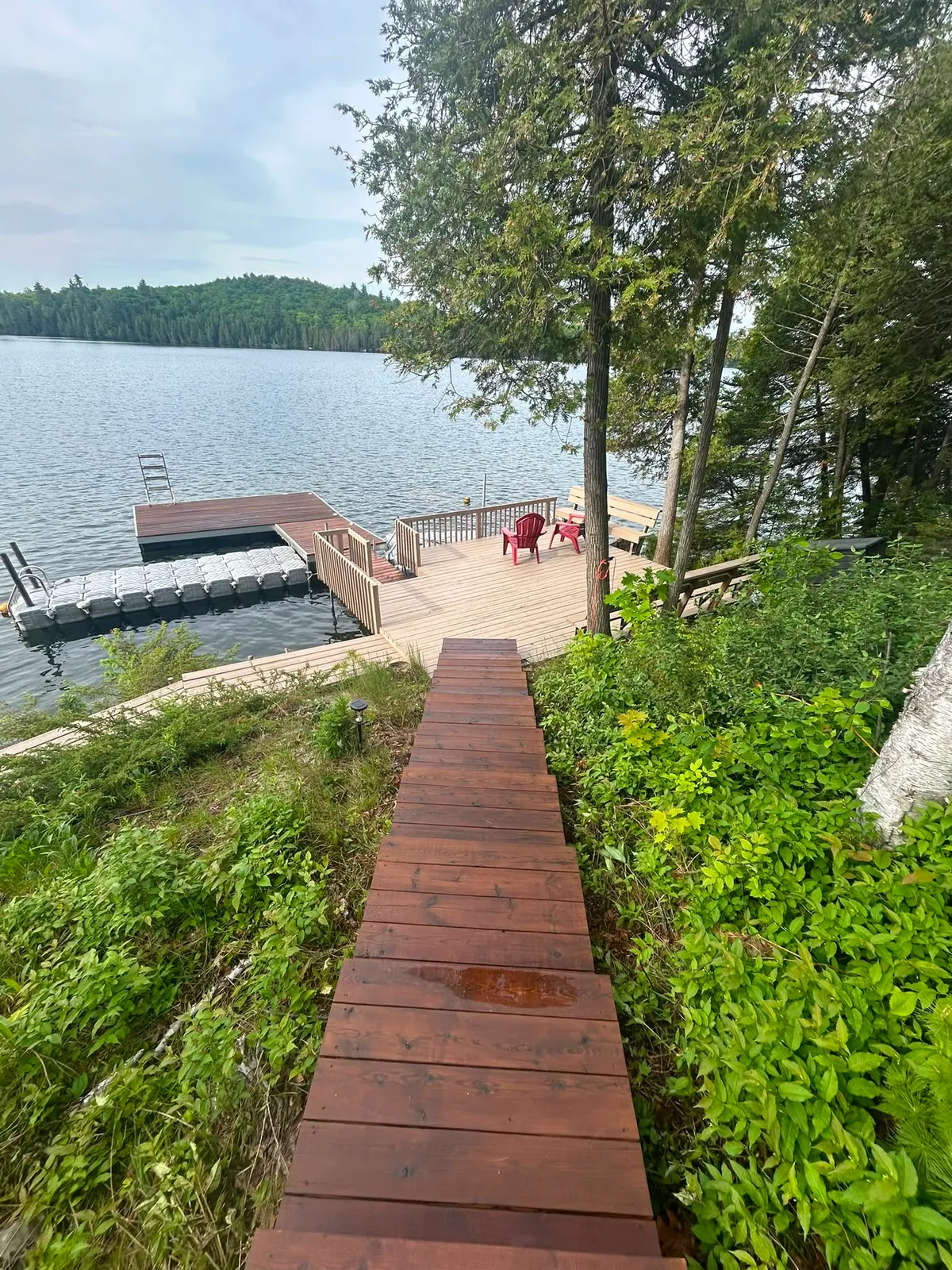 Freshly stained deck and dock walkway leading to a lake