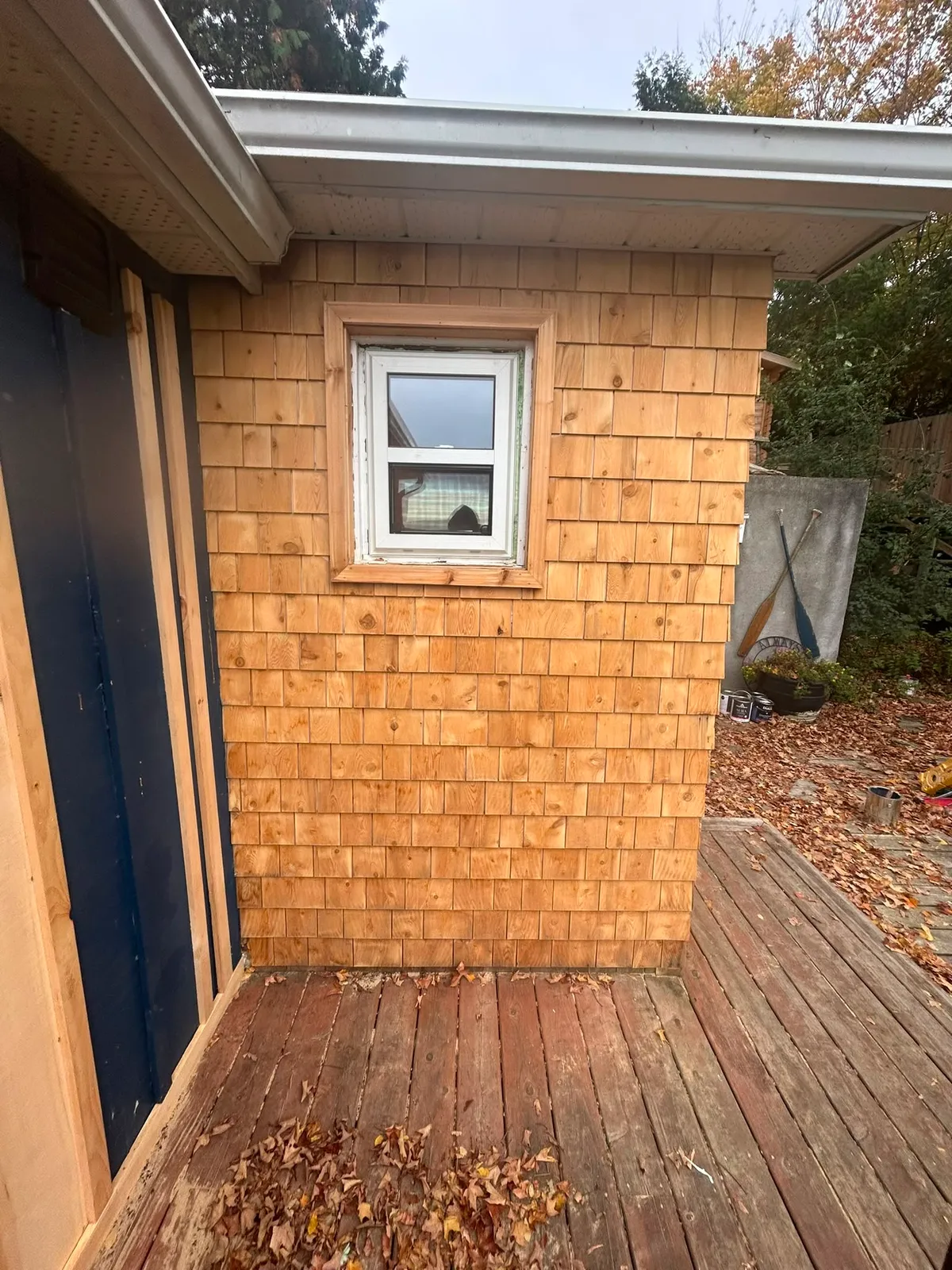 Cedar shingle siding freshly stained with navy trim